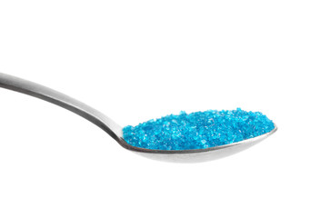 Spoon with color sugar on white background