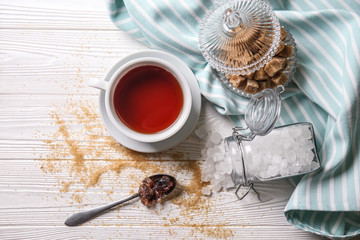 Different sugar with cup of tea on white wooden table