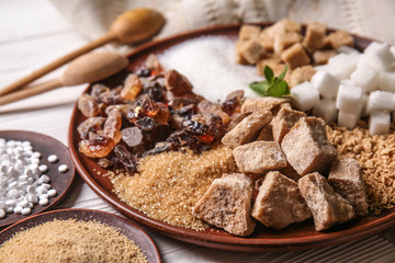 Different kinds of sugar on white wooden table