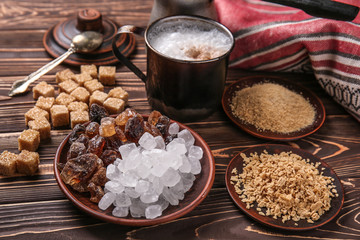 Different kinds of sugar with coffee on wooden table