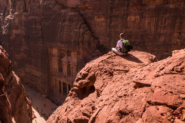 Aerial view of Treasury with a tourist, hiker, solo traveler, young man backpacker seated on a...