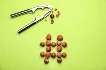 Hashtag sign made of hazelnuts and nutcracker on color background