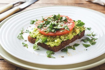 Avocado toast. Healthy toast with avocado mash and tomatoes on a plate.