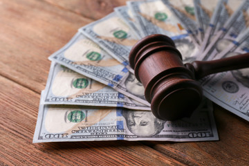 Judge's gavel with dollar banknotes on wooden table. Corruption concept