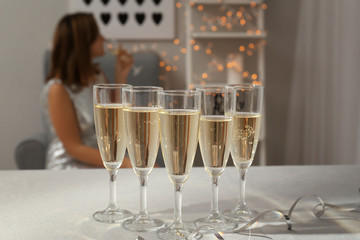 Glasses of champagne on white table in room