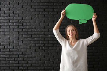 Young woman with blank speech bubble on dark background