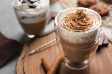 Glass of tasty aromatic latte on wooden board