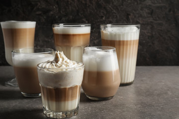 Glasses of tasty aromatic latte on grey table