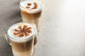 Glasses of tasty aromatic latte on grey table
