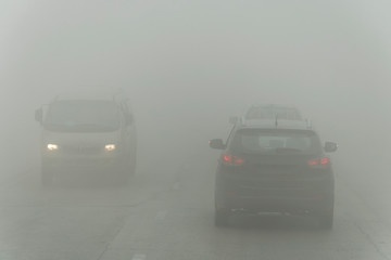 Dense fog and poor visibility on the road. Dangerous driving situations. View on highway traffic....