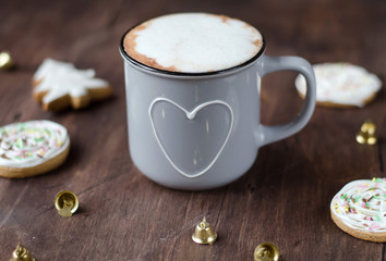 Cozy Cup of cocoa with Christmas gingerbread on a wooden table.
