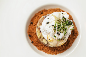 Herring tartar with poached egg on plate, closeup