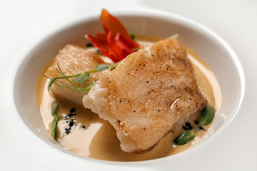 Tasty fish with sauce on plate, closeup