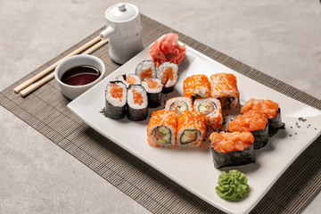 Set of tasty sushi rolls on grey table