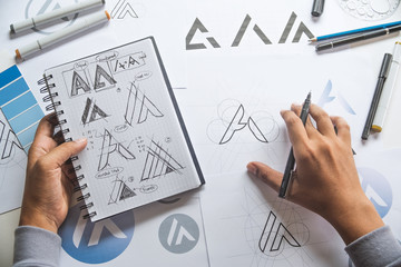 Graphic designer drawing sketch design creative Ideas draft Logo product trademark label brand artwork. Graphic designer studio Concept. - obrazy, fototapety, plakaty