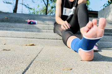 Hand female using elastic bandage with legs,Female putting bandage on her injured foot from sport.