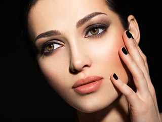 Face of a beautiful girl with fashion makeup and black nails