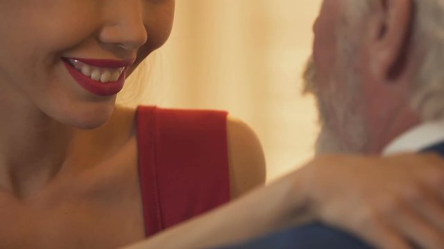 Sexy lady sending air kiss to old man, seducing oligarch, dreaming of wealth