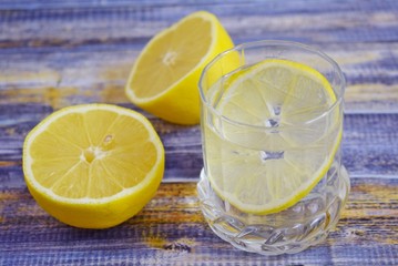 Homemade lemonade with fresh lemon on wooden background.