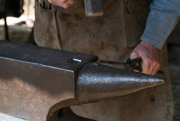 Blacksmith at work with hammer and anvil