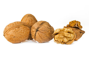 Walnuts and cracked walnut with leaves, isWhole fruits and grains of walnut on a white background. three walnuts on a white background. Native fruits of the Greek nuts and grains on a white background