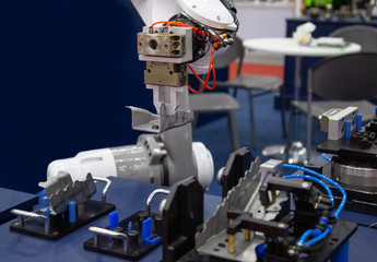 Fototapeta premium Industry automated robot arm loading and unloading workpieces in production line. Industrial manufacturing