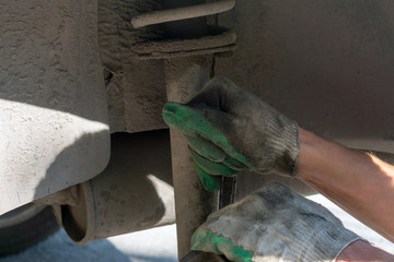 Repair of the car suspension. Gloved hand. Replacing the shock absorber strut.