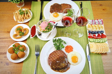 A two man steak dinner with side dishes