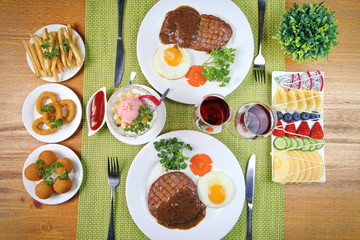 A two man steak dinner with side dishes