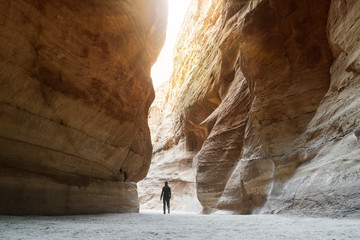Tourist in narrow passage of rocks of Petra canyon in Jordan. UNESCO World Heritage Site. Way...