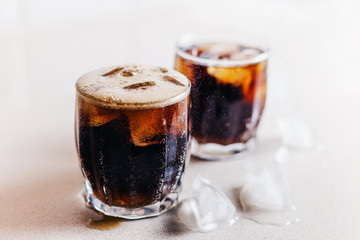 Closeup of whiskey and cola in glasses with ice on the bar counter of the restaurant - small air bubbles - soda
