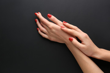 Female hands with manicure on dark background