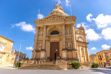 Fototapeta na wymiar Gozo, Malta - May 22nd 2018 - A catholic church in a blue sky day in Gozo island in the north of Malta
