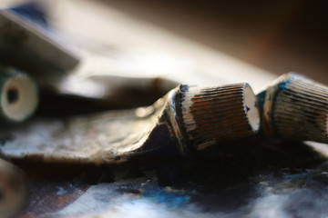 old tubes of oil paint blue and turquoise colors are on the palette