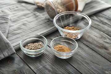 Bowls with spices on wooden table