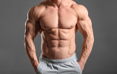 Fototapeta na wymiar Muscular bodybuilder on grey background