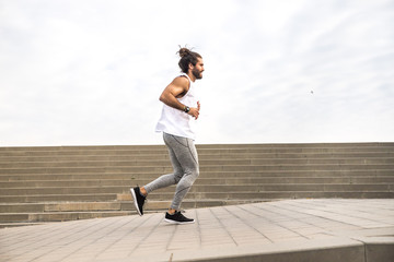 young man with long hair wearing sport wear running