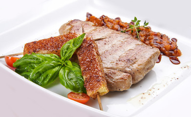 Pork steak with vegetable salsa on white background