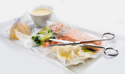 Salmon cooked sous vide with vegetables on a white background