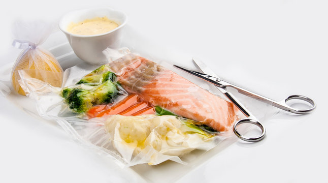 Salmon cooked sous vide with vegetables on a white background