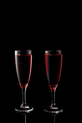 Glasses of rose champagne on dark background