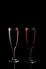 Glasses of rose champagne on dark background