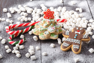 Cookies in the shape of a Christmas tree is lit on the wooden background