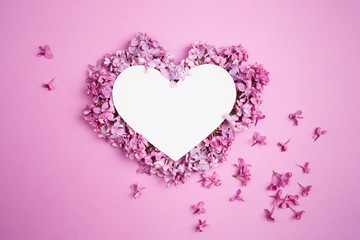 white heart decorated with lilac flowers on purple pink background. Card for Valentine's day, mother's day, women's day with love