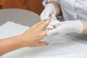 Massage therapist massaging hands of a woman in a beauty salon