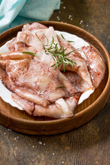 Fresh Squid, Various Spices and Olive Oil on a wooden table.