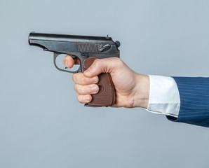 Male hand with a gun close up