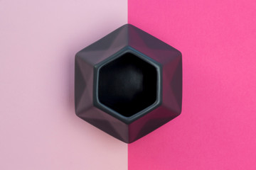 Grey polygonal vase on the geometric background of fashion pink and magenta bright colors, vertical...