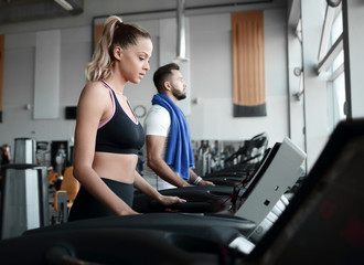 Fototapeta na wymiar beautiful sports people work on the treadmill in the gym