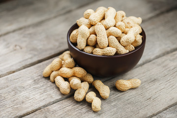 Peanuts in the shell, in a wooden cup on the table.